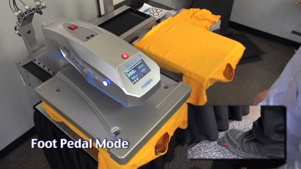 Hotronix Dual Air Fusion IQ Heat Press with two t-shirts laid out side by side, with a close of a person’s foot on the foot pedal, in Foot Pedal Mode